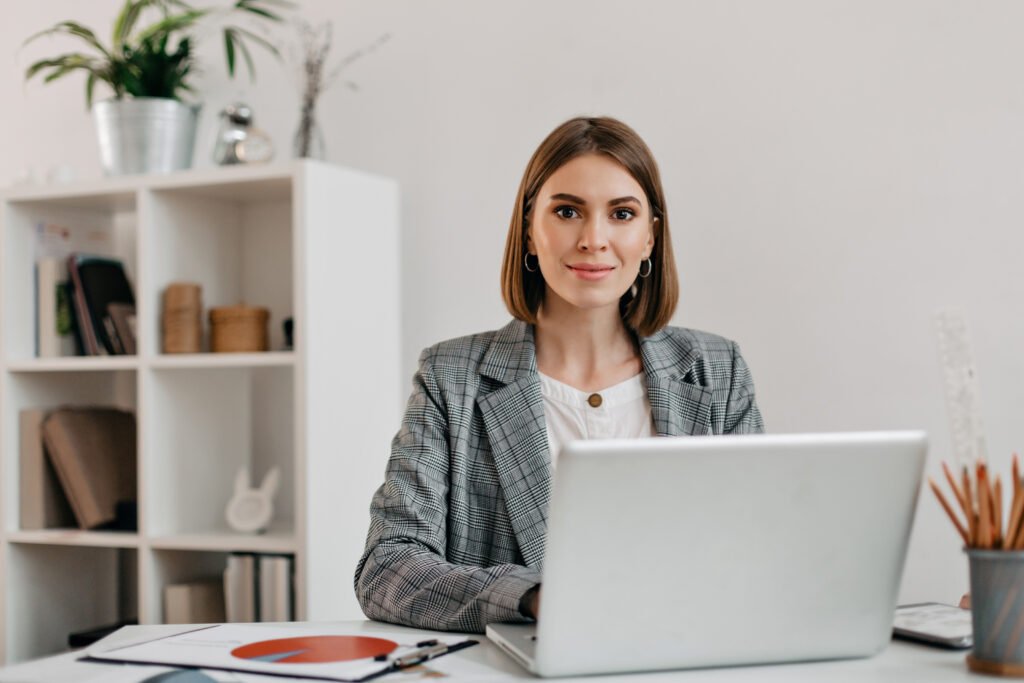 business woman checkered jacket with smile while sitting desk her office